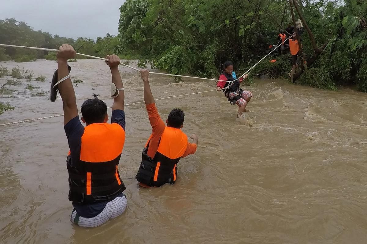 Photo shows rescuers evacuating residents from their homes near a swollen river due to heavy rains brought about by Tropical Storm Kompasu in Gonzaga town, Cagayan province, north of Manila. Credit: AFP Photo