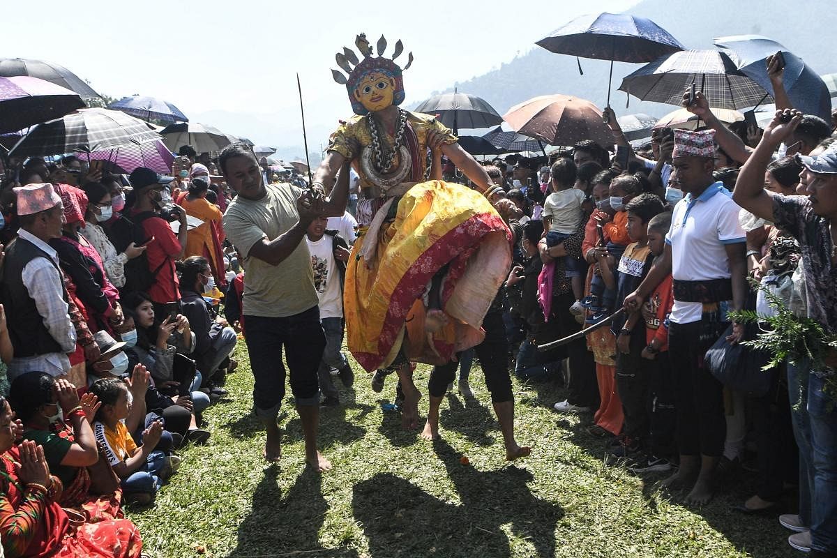 A Hindu devotee dressed as a deity (C) participates during celebrations for the Shikali Jatra festival at Khokana village, on the outskirts of Kathmandu. Credit: AFP Photo