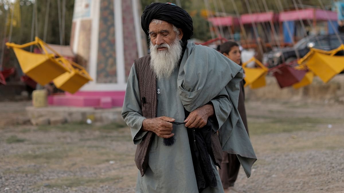 A Taliban fighter walks as he and others take a day off to visit the amusement park in Kabul, Afghanistan. Credit: Reuters Photo