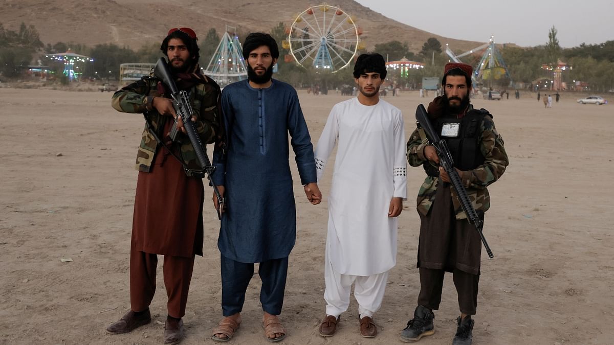 Park visitors pose with Taliban fighters from Wardak province during their first visit to Kabul as they take a day off to visit the amusement park. Credit: Reuters Photo