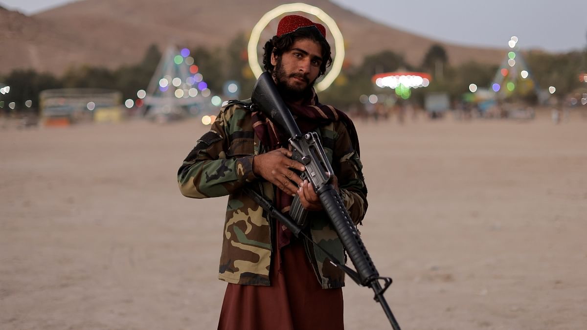 Taliban fighter, Mostashhed from Wardak province, looks on as he poses for a photo outside the amusement park at Kabul's Qargha reservoir, in Afghanistan. Credit: Reuters Photo