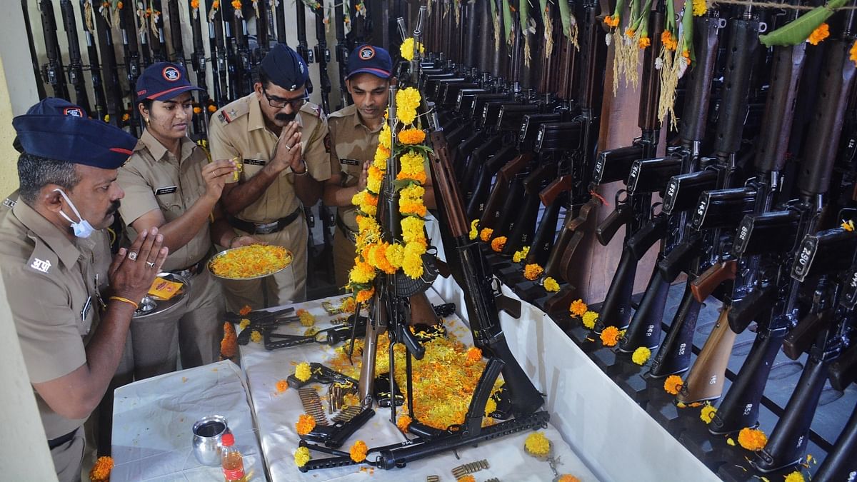 Police personnel perform 'Shastra Puja' on the occasion of 'Vijaya Dashami' at the Police Commissionerate armoury in Thane. Credit: PTI Photo