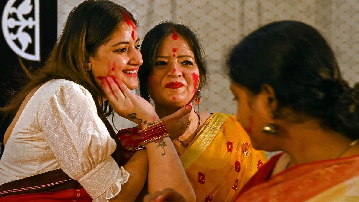 Women apply vermilion powder on each other during the 'Sindoor Khela' in Delhi. Credit: AFP Photo