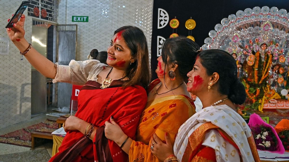 Married women are seen clicking selfies after playing 'Sindoor Khela' in Delhi. Credit: PTI Photo