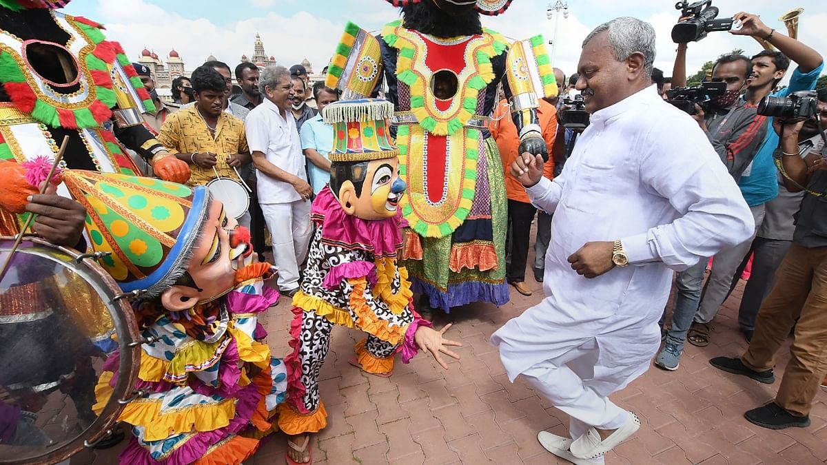District Minister ST Somashekar dances with folk artists as the idol of Goddess Chamundeshwari is brought from the Chamundi Hills to the Mysuru Palace. Credit: PTI Photo