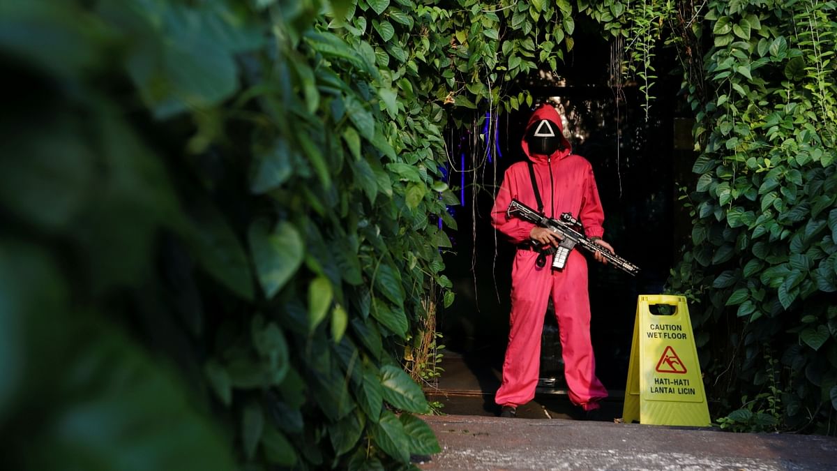 A guard is seen in a 'Squid Game' costume as he stands guard at Strawberry Cafe in Jakarta, Indonesia. Credit: Reuters Photo