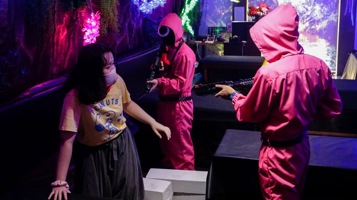 A customer plays 'Red Light, Green Light' game from the Netflix show 'Squid Game' with the staff members at Strawberry Cafe in Jakarta, Indonesia. Credit: Reuters Photo