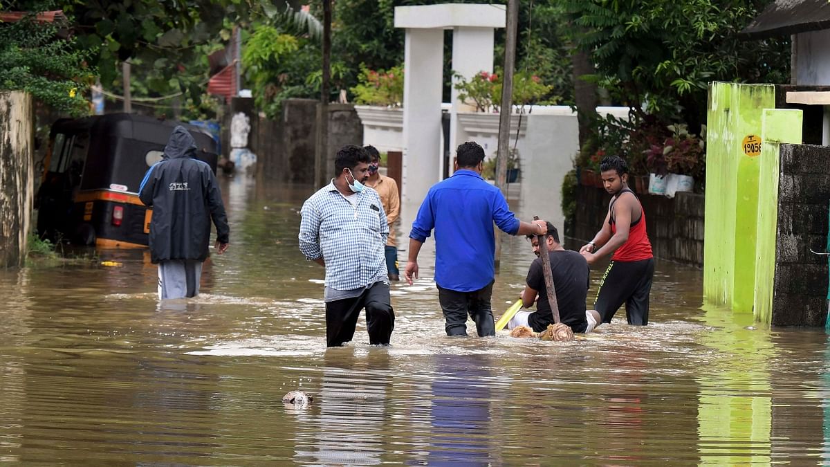 Residents wade through a flooded street after a heavy rainfall in Thiruvananthapuram. Credit: PTI Photo