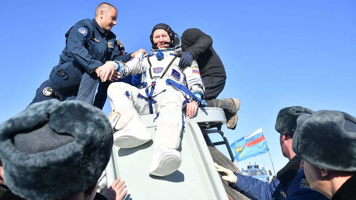 Russian cosmonaut Oleg Novitsky, is helped to disembark after the landing of the Russian Soyuz MS-18 space capsule in Kazakhstan. Credit: Russian Space Agency Roscosmos/AFP Photo