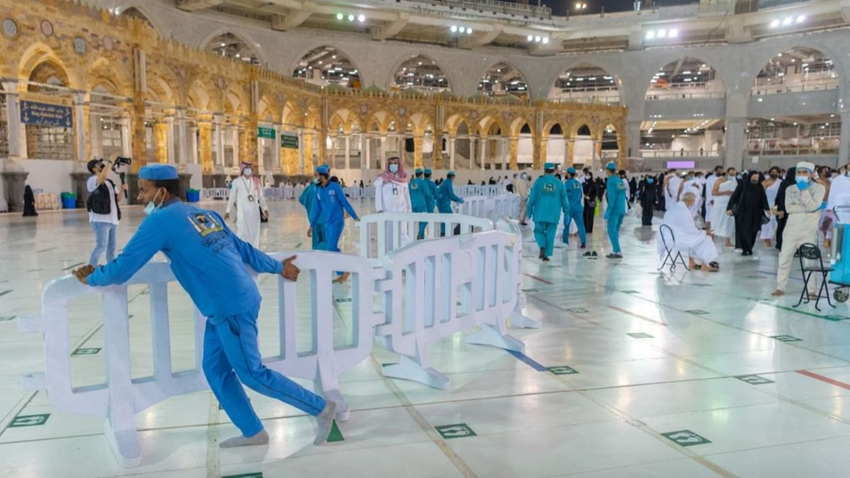 Officials removing social distancing barriers at the Grand Mosque in the Saudi holy city of Mecca. Credit: Saudi Press Agency/Handout via Reuters