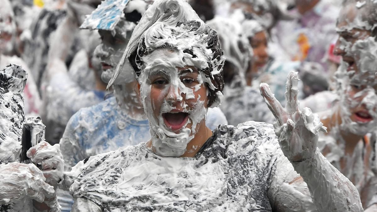 A student gestures during the mass foam fight on the Lower College Lawn in St Andrews, Scotland. Credit: AFP Photo