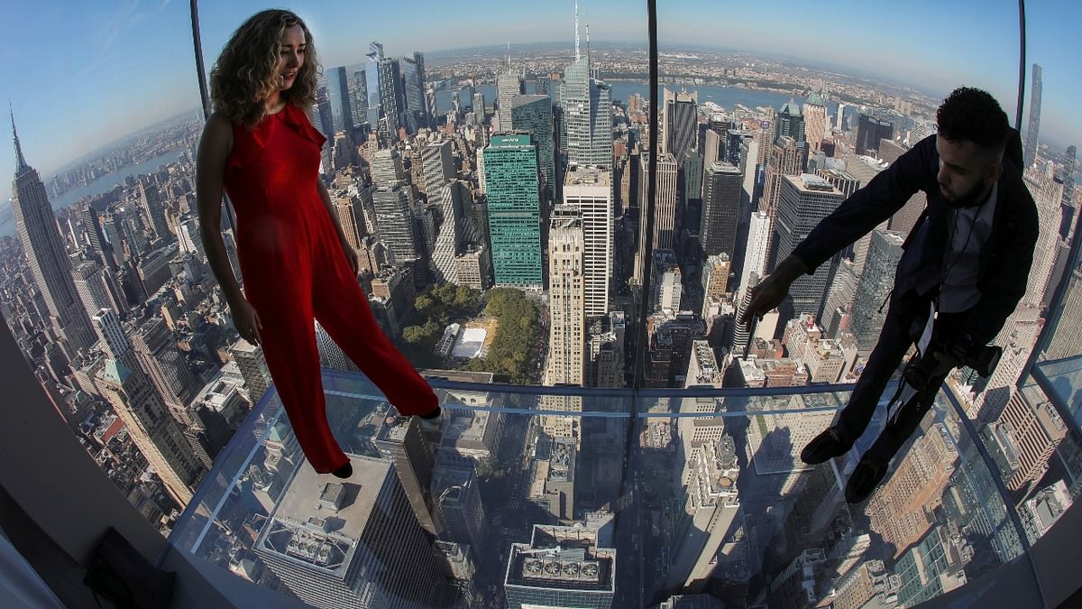 A woman poses for a photographer on one of the transparent floors above the New York City skyline. Credit: Reuters Photo