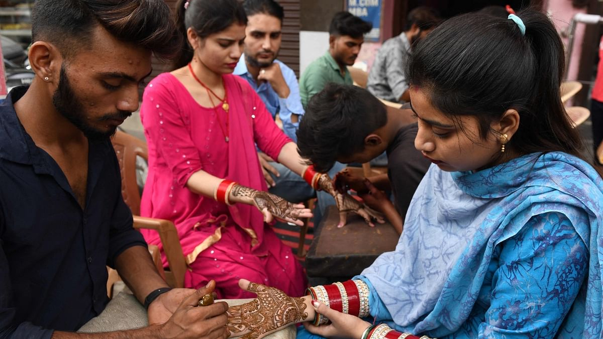 Women get their hands decorated with henna for the eve of the Karva Chauth in Amritsar. Married women fast one whole day and offer prayers to the moon for the welfare, prosperity, and longevity of their husbands. Credit: AFP Photo