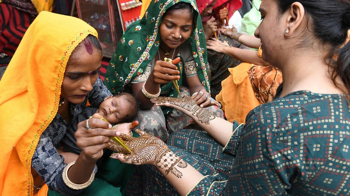 A married woman gets her hands decorated with henna on the eve of the Karva Chauth festival in Amritsar. Credit: AFP Photo