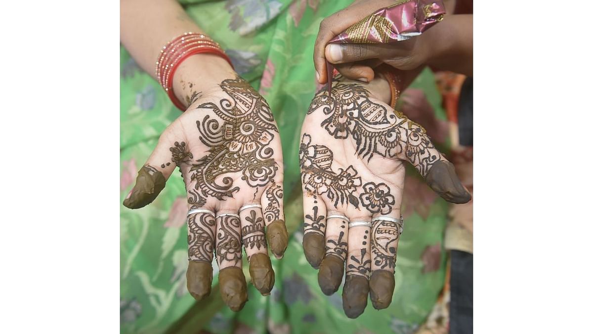 Women apply henna on their hands on the eve of 'Karva Chauth' festival in Kolkata. Credit: PTI Photo