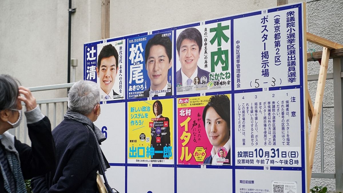 Voters look at an election poster bulletin board for House of Representatives election candidates at an entrance of a polling station in Tokyo. Credit: AFP Photo