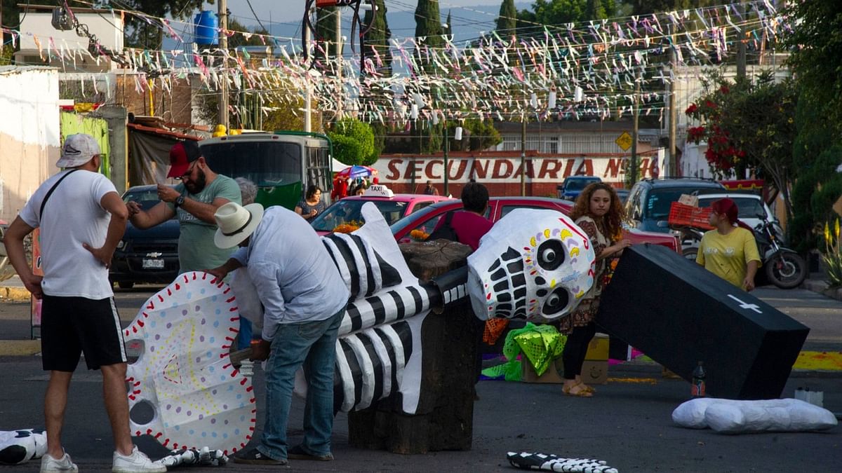 People make a skeleton out of cardboard on a street in Santa Cecilia neighbourhood in Mexico City ahead of the Day of the Dead celebrations. Credit: AFP Photo