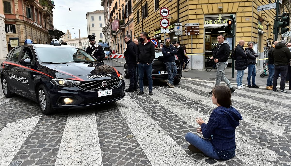 A person blocks a Carabinieri car as Extinction Rebellion activists protest during the G20 summit in Rome. Credit: Reuters Photo