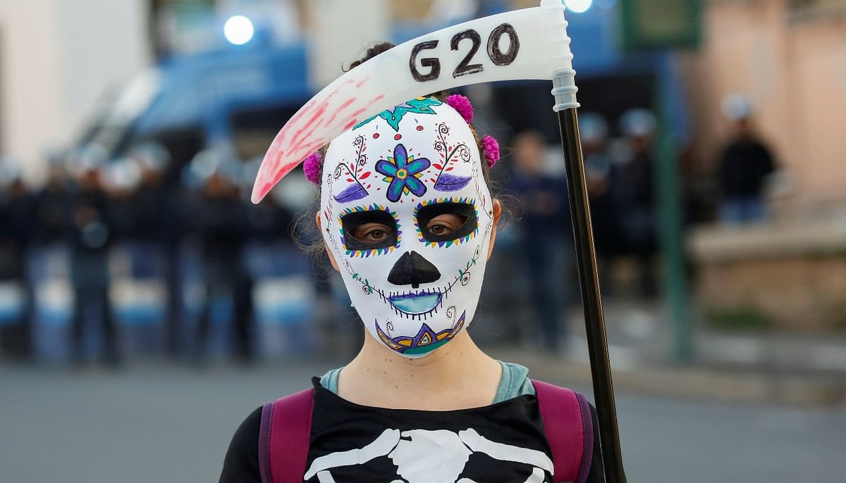 A demonstrator wears a mask while staging a protest during the G20 summit in Rome, Italy. Credit: Reuters Photo