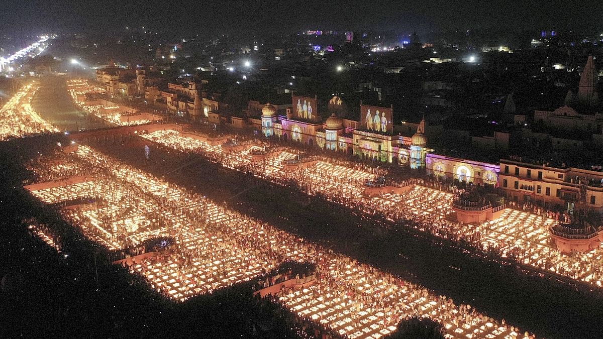 Devotees are seen lighting earthen lamps on the bank of Saryu River during Deepotsav celebrations in Ayodhya. Credit: PTI Photo