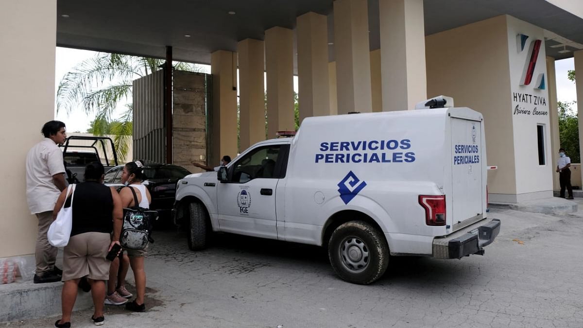 Hotel workers chat next to a vehicle from the coroner's office parked at the entrance to a hotel after two suspected drug gang members were shot dead in a beachfront clash between rival groups near the Mexican resort of Cancun, in Puerto Morelos. Credit: Reuters photo