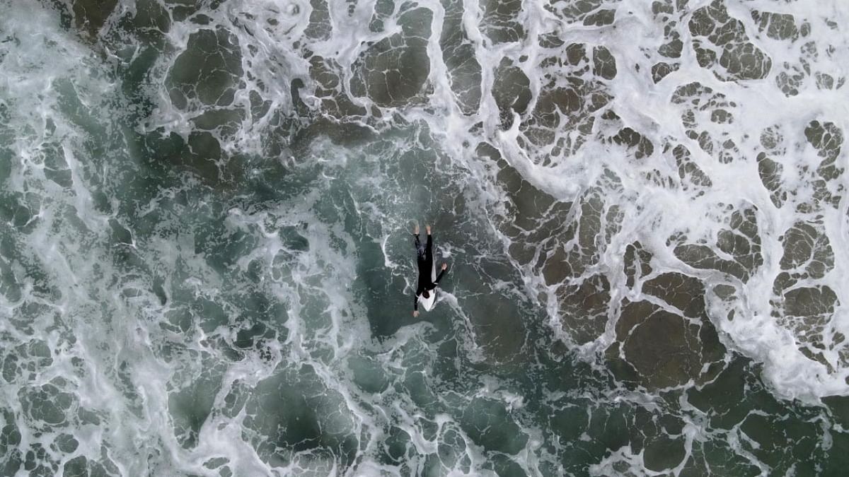 A surfer takes to the waves about a month after an oil spill closed Huntington Beach, California. Credit: Reuters photo