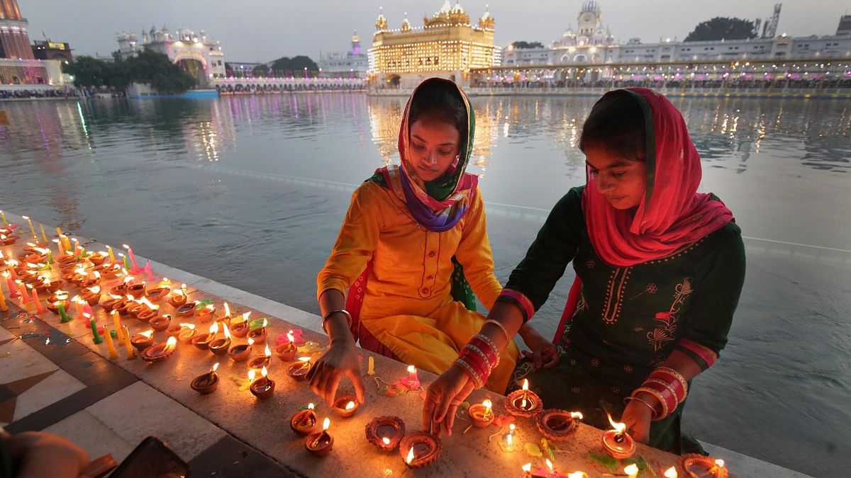 Devotees light 'diyas' and candles at the Golden Temple in Amritsar. Credit: PTI Photo