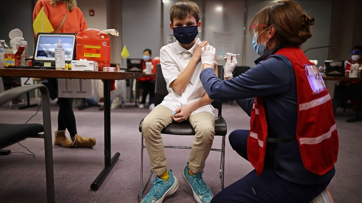 A young boy gets clicked as he receives the Pfizer BioNTech Covid-19 vaccine at the Fairfax County Government Center in US. Credit: AFP Photo