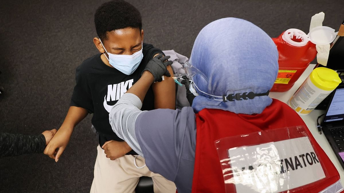 A young boy reacts as he receives the Pfizer BioNTech Covid-19 vaccine at the Fairfax County Government Center in US. Credit: AFP Photo