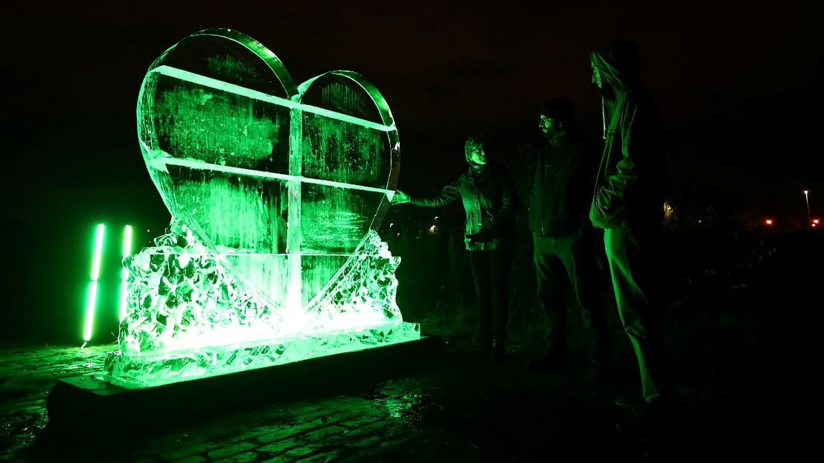 People look at a climate action ice sculpture that was unveiled on the bank of the River Clyde during the UN Climate Change Conference (COP26) in Glasgow, Scotland. Credit: Reuters Photo