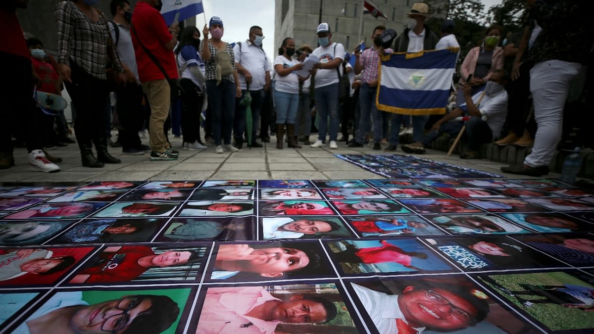 Pictures of people killed by Nicaraguan forces in 1998 during the anti-government protests, lie on the floor during a march of Nicaraguans exiled in Costa Rica to protest against the presidential election in Nicaragua, in San Jose, Costa Rica. Credit: Reuters Photo