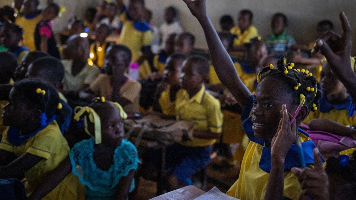 Julianese, 11, raises her hand to answer a question in a classroom with over 60 students at the St. Michael Catholic school in Cite Soleil, Port-au-Prince, Haiti. Credit: Reuters Photo