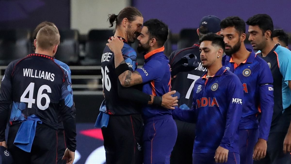 Virat Kohli hugs Namibia's David Wiese as he leads team members out into the field after winning the T20 World Cup match between India and Namibia in Dubai. Credit: AP/PTI Photo