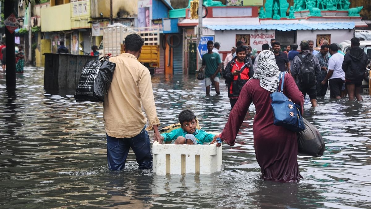 A family wades through a waterlogged area following heavy rain in Chennai. Credit: PTI Photo
