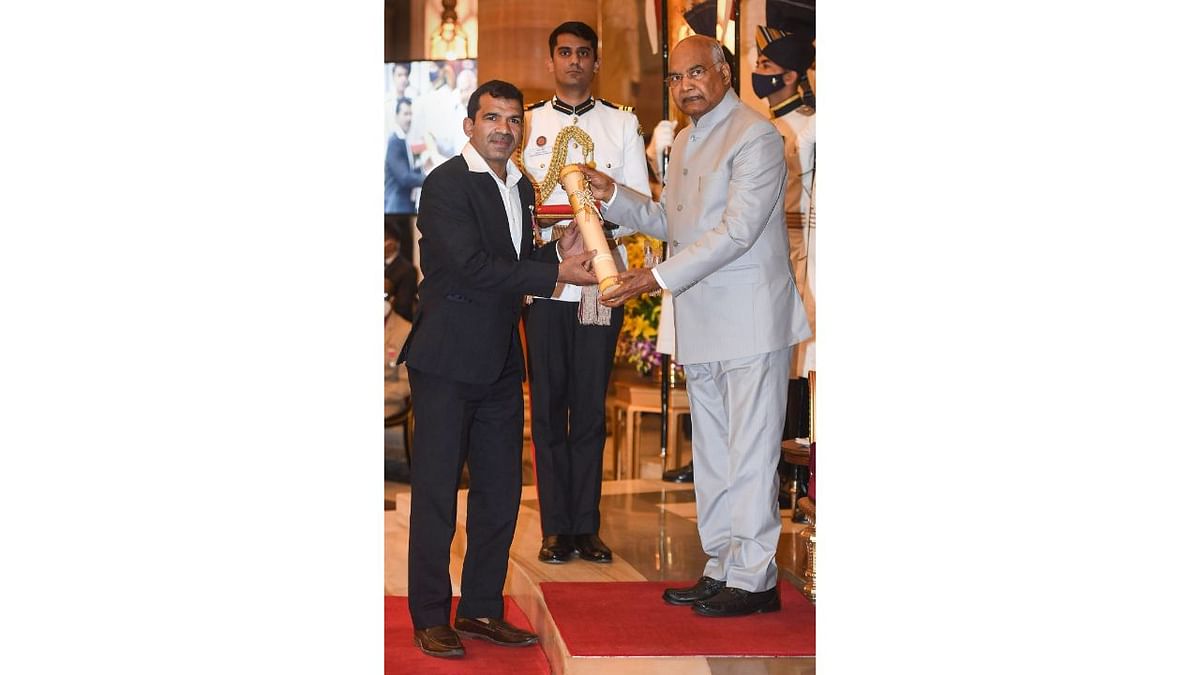 President Ram Nath Kovind presents the Padma Shri award to wrestler Virender Singh during a ceremony at Rashtrapati Bhawan in New Delhi. Credit: Twitter/@rashtrapatibhvn
