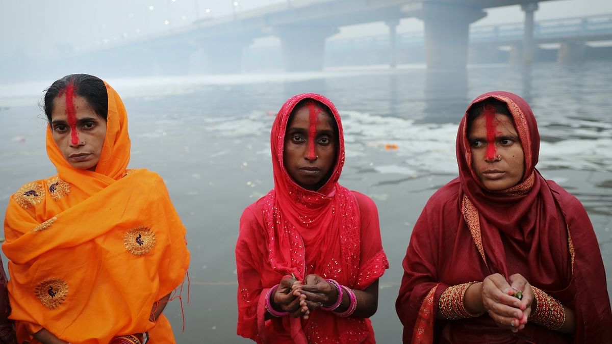 Women worship the Sun God as they stand in Yamuna river in New Delhi. Credit: Reuters Photo
