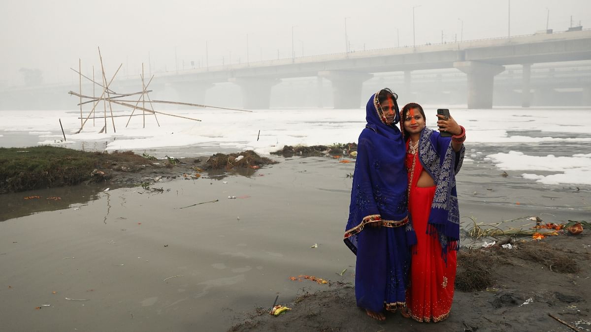 Women take a selfie after worshiping the Sun God on the banks of Yamuna river during the Chhath Puja in New Delhi. Credit: Reuters Photo