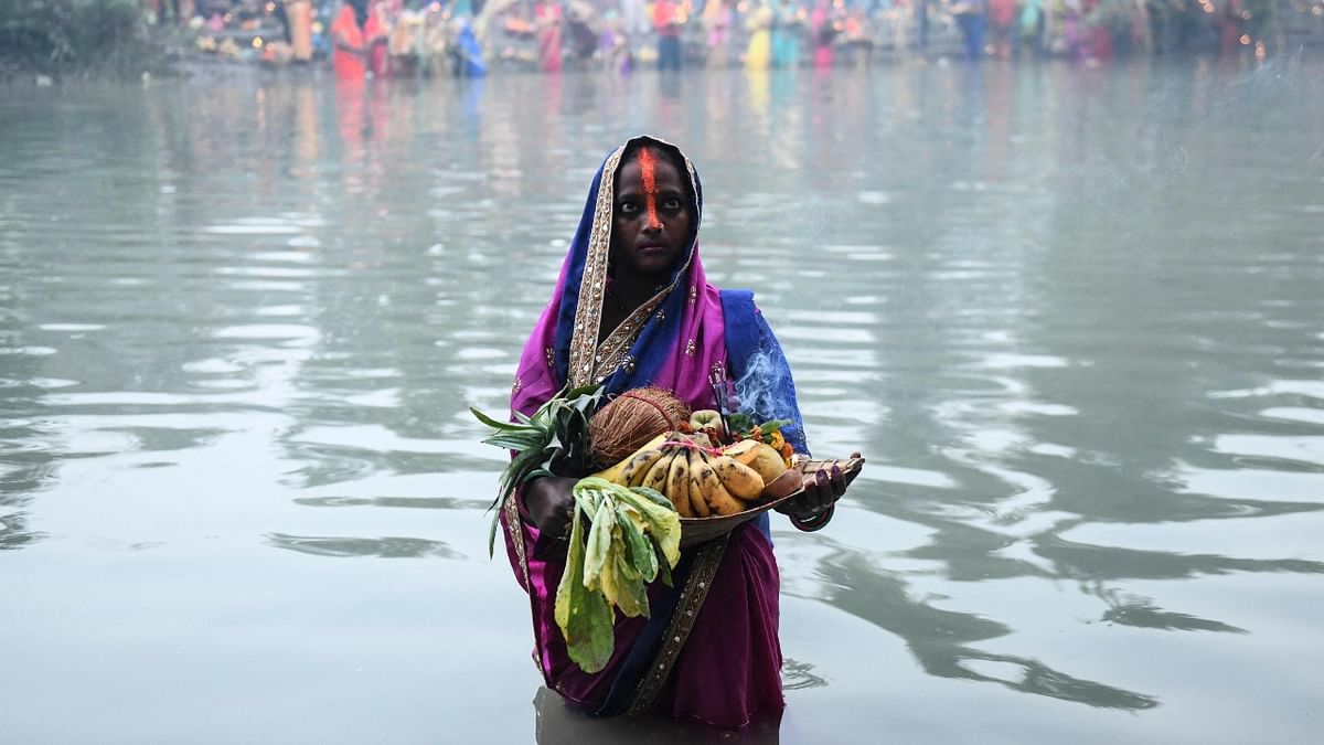 A devotee performs rituals during the last day of the Chhath Puja festival along a river on the outskirts of Amritsar. Credit: AFP Photo