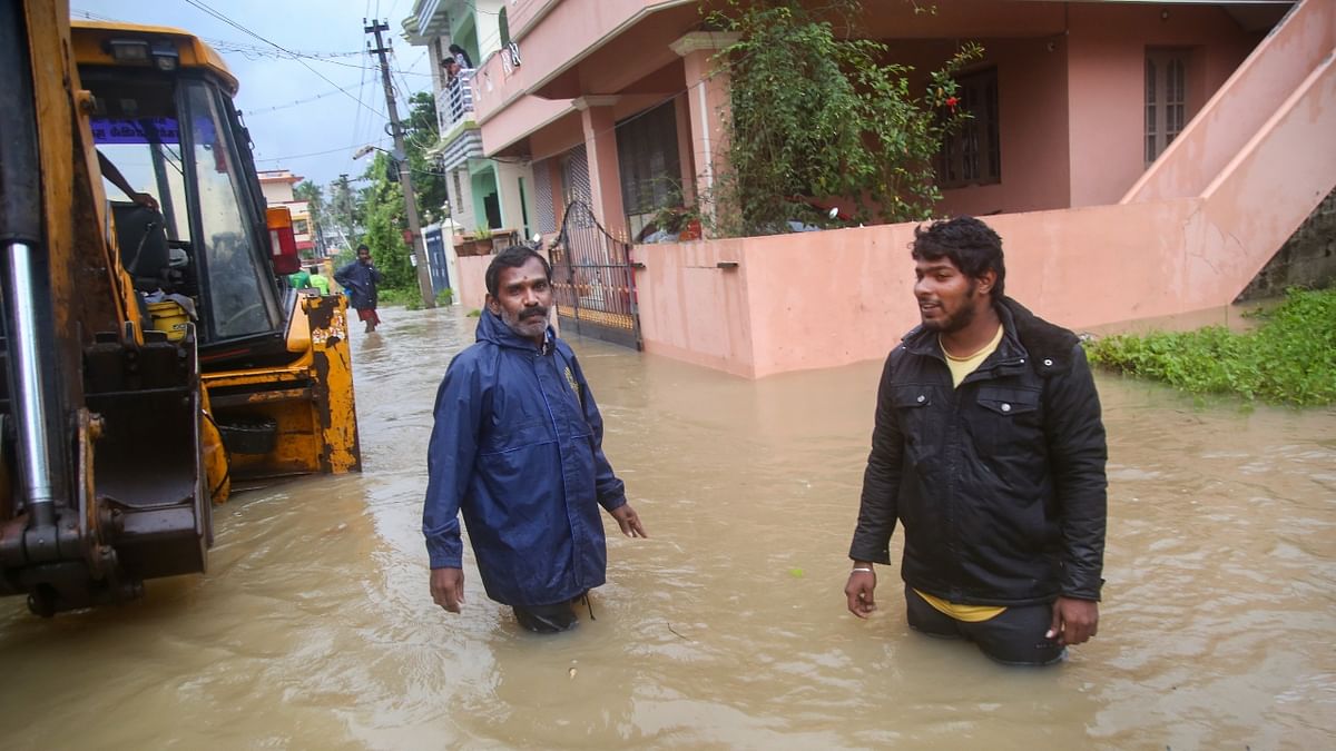People are seen standing in a waterlogged areas in Nagercoil, Kanyakumari. Credit: PTI Photo