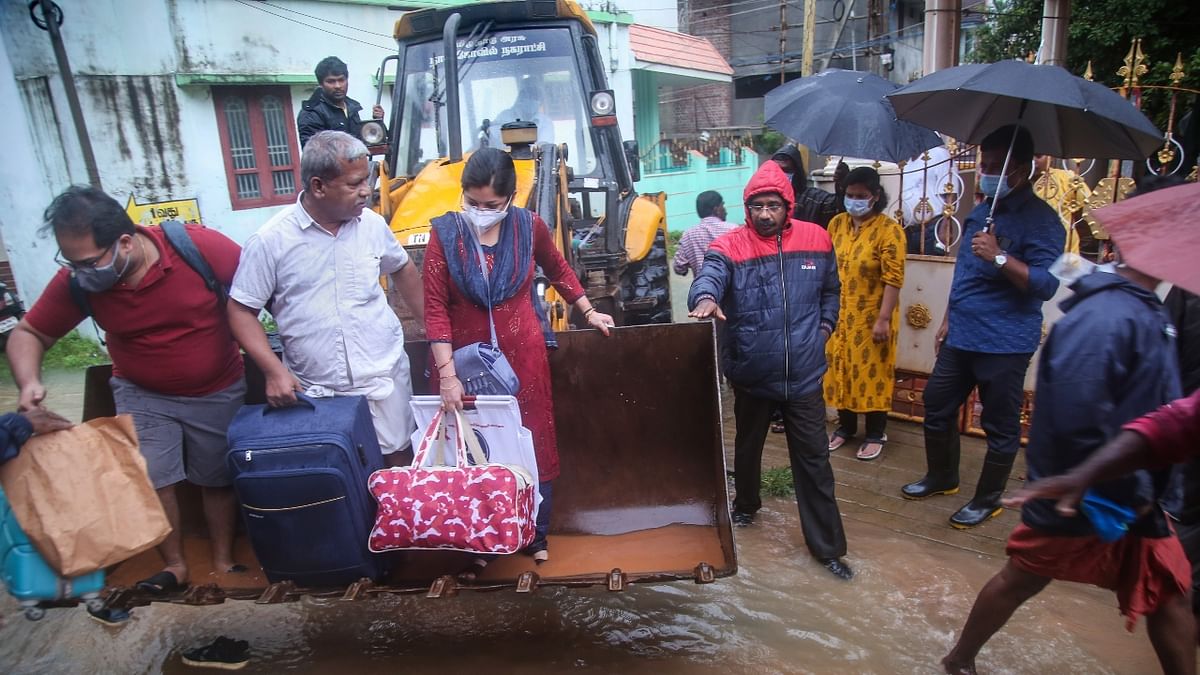 People being rescued using earth mover in a waterlogged area in Nagercoil. Credit: PTI Photo