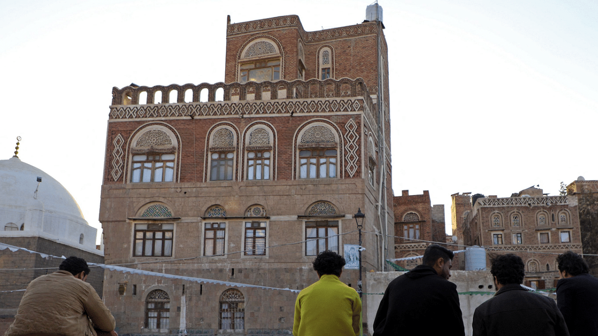 Youths sit in front of UNESCO-listed buildings in the old city of the Yemeni capital Sanaa. Credit: AFP Photo