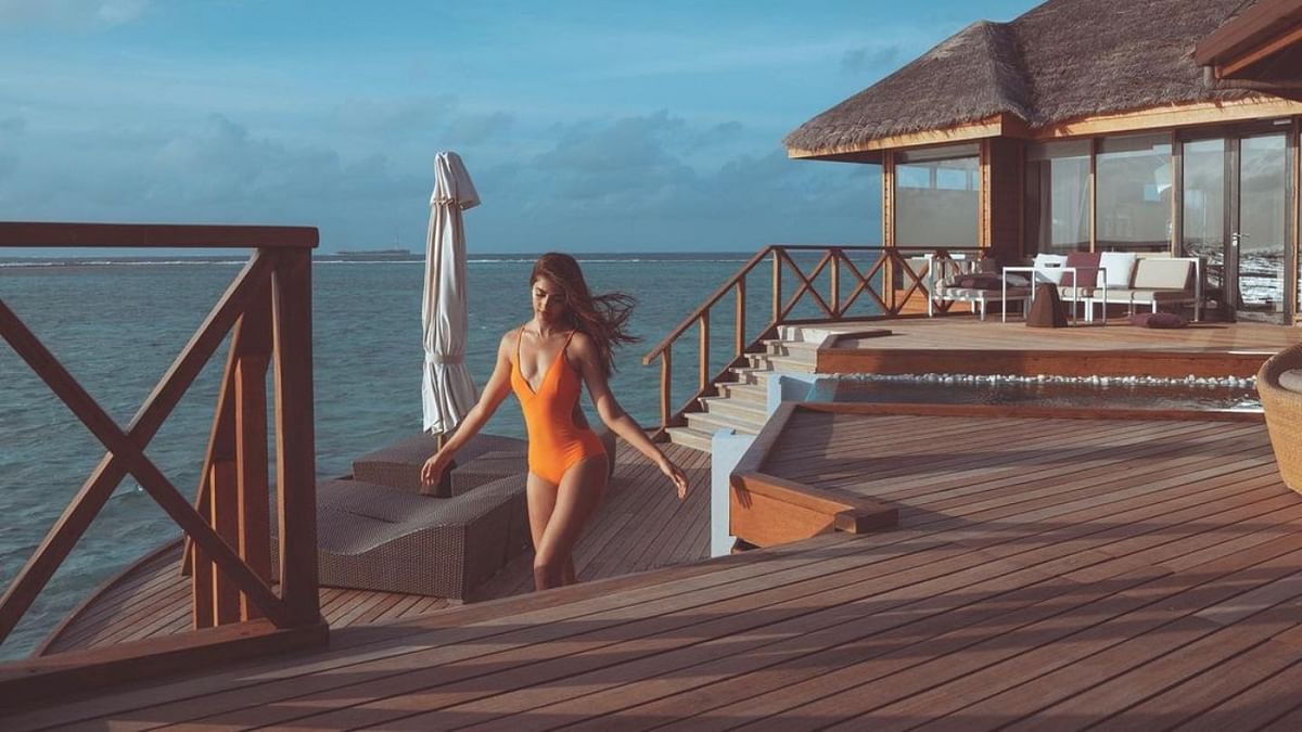Pooja is seen showing off her beach body in orange swimwear. Credit: Instagram/hegdepooja