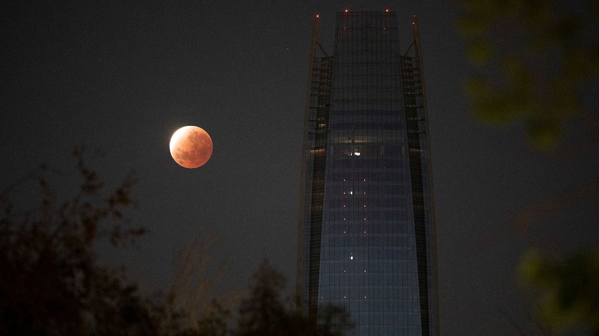 A partial lunar eclipse dubbed the 'blood moon' is seen next to the Gran Torre building in Santiago, Chile. Credit: Reuters Photo