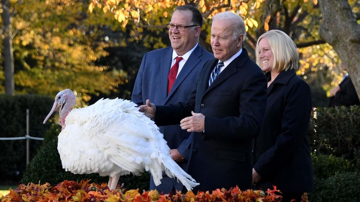 US President Joe Biden pardons the turkey 'Peanut Butter' as Andrea Welp (R), turkey grower from Indiana, and Phil Seger, chairman of the National Turkey Federation, look on during the White House Thanksgiving turkey pardon in the Rose Garden of the White House. Credit: AFP Photo