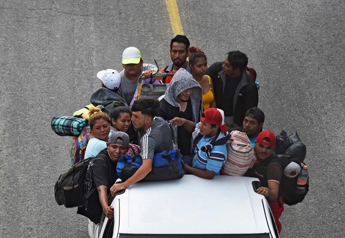 Migrants heading in a caravan to the US, ride on the back of a truck in El Arenal, Sayula de Aleman municipality, Veracruz state, Mexico. Credit: AFP Photo
