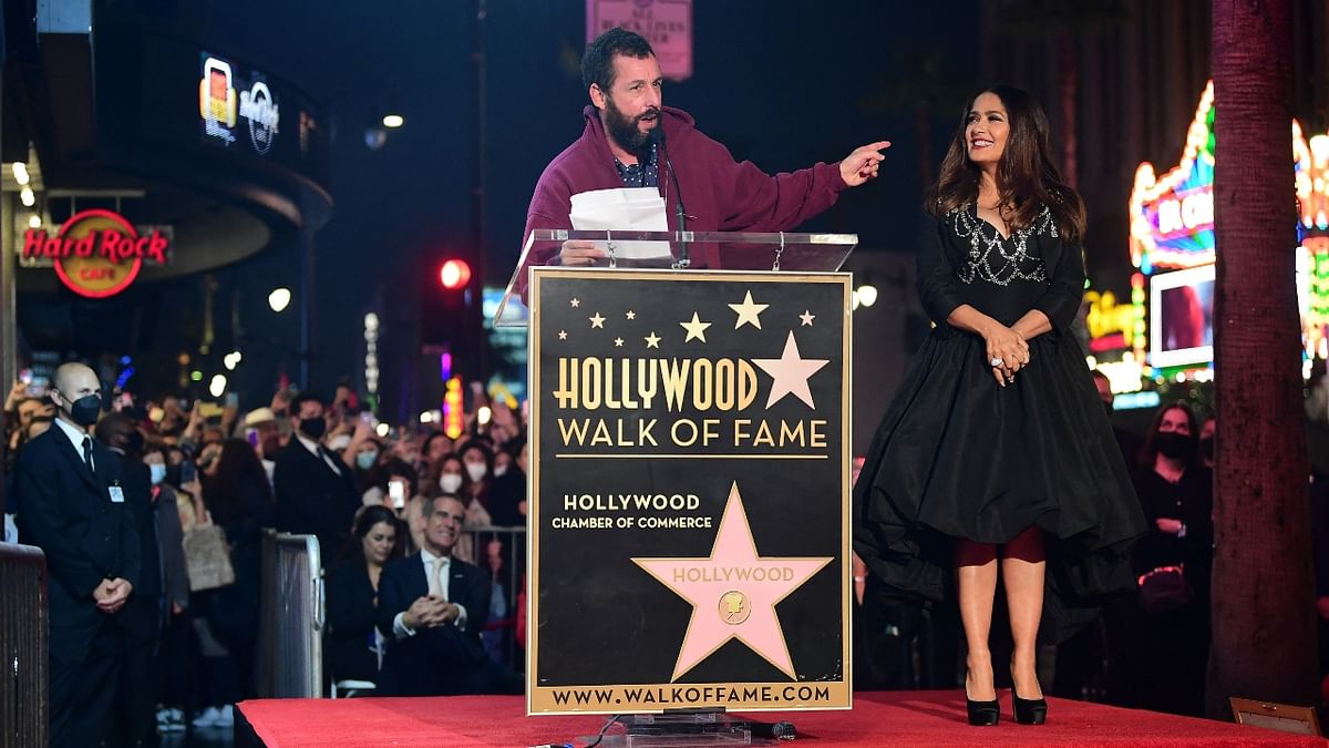 Adam Sandler speaks as Salma Hayek looks on during the Hollywood Walk of Fame Star unveiling ceremony in Hollywood, California. Hayek and Sandler worked together in the Grown Ups (2010) and its sequel in 2013. Credit: AFP Photo