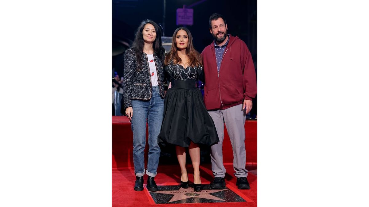 Salma Hayek, flanked by Chloe Zhao and Adam Sandler. Credit: AFP Photo