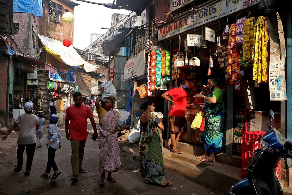 People walk past stores selling consumer goods in an alley in Dharavi, Mumbai. Credit: Reuters Photo