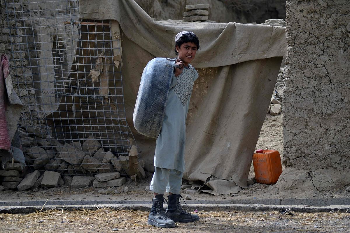 A youth poses for a picture after throwing garbage in front of a house in Kandahar. Credit: AFP Photo