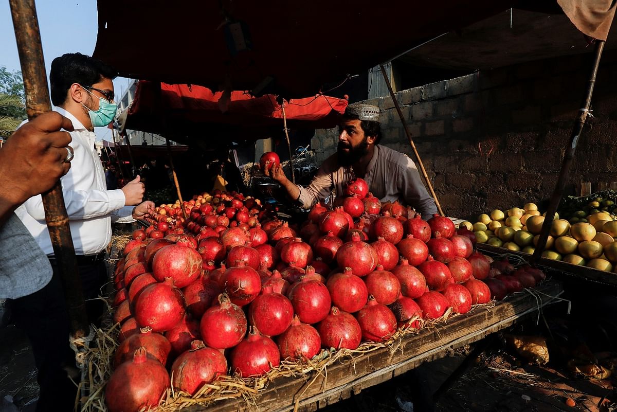 A fruit vendor speaks with a customer while selling pomegranates from Afghanistan. Credit: Reuters Photo